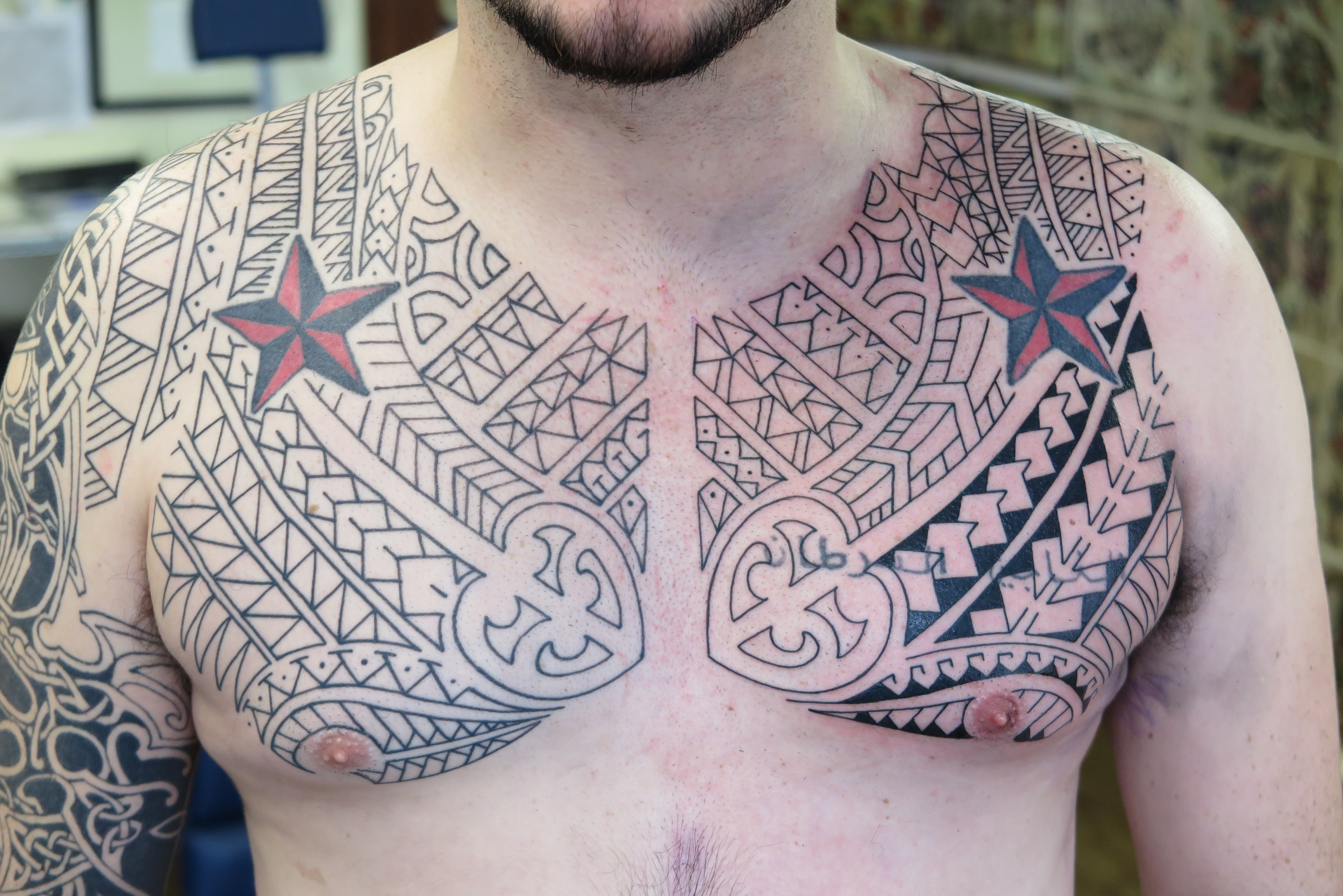 Polynesian style sleeve and chest tattoo.